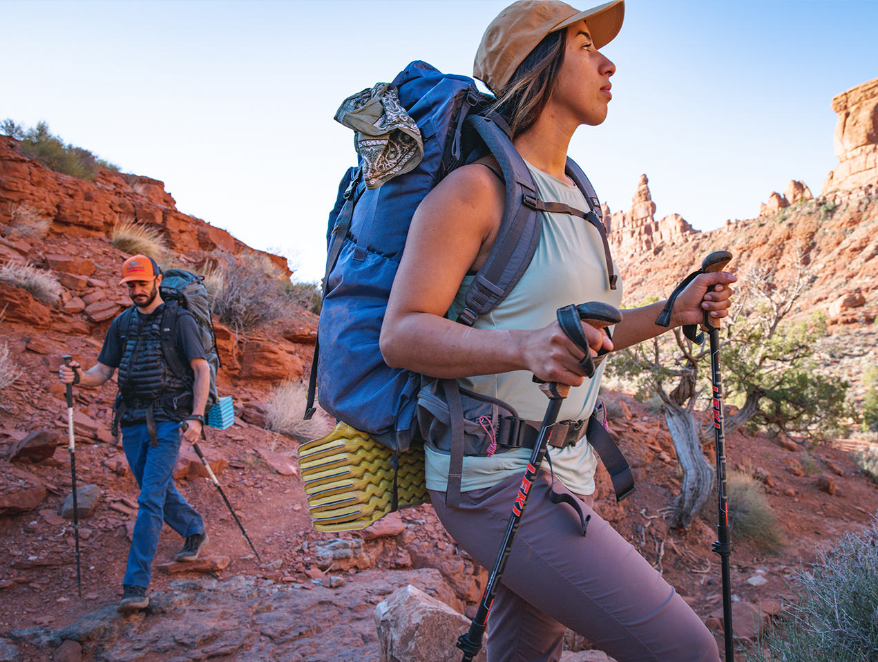On the move! Two backpackers wearing the PCT on trail in the Utah Desert