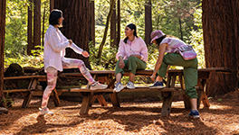 Three Women on an outdoor picnic table getting ready to hike