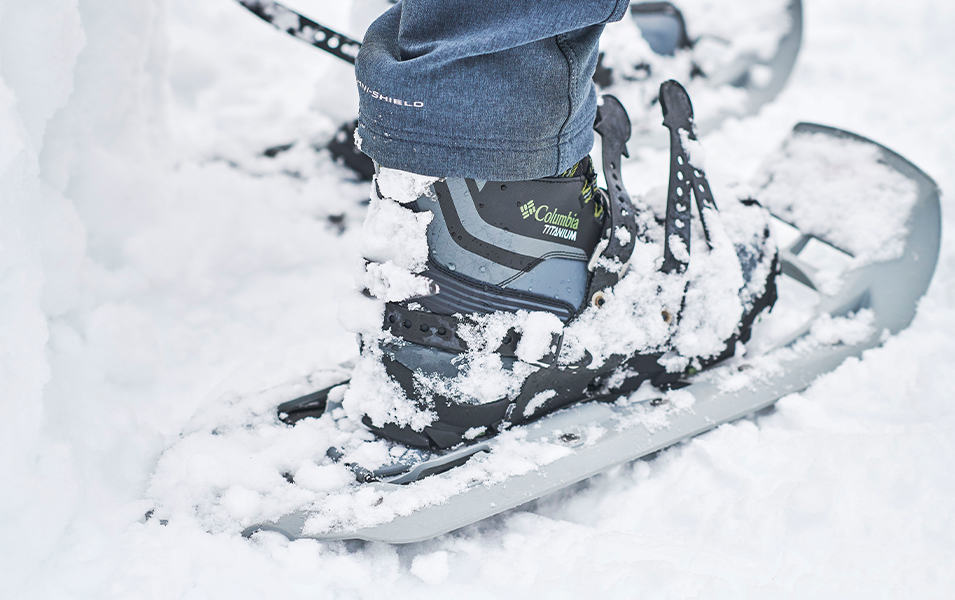 Close up of Titanium Columbia boots and snowshoes in snow. 