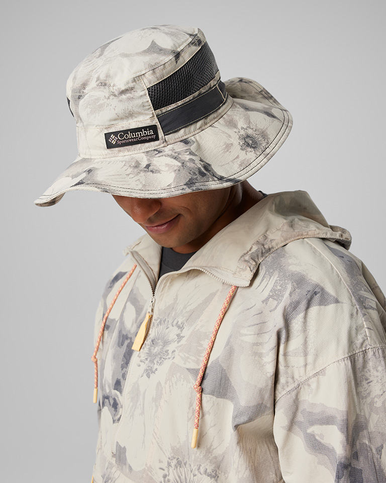A man in a grey floral bucket hat and matching windbreaker.
