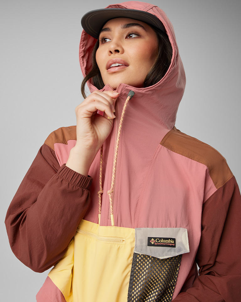 A woman in a pink and yellow, vintage-looking windbreaker.