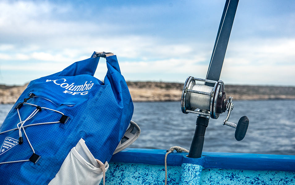 Close up PFG bag and reel leaning against the side of the boat. 
