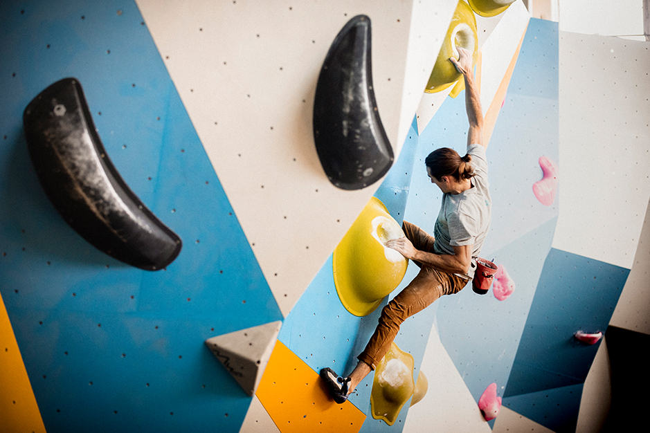 Ethan boulders in a colorful gym in San Francisco. 