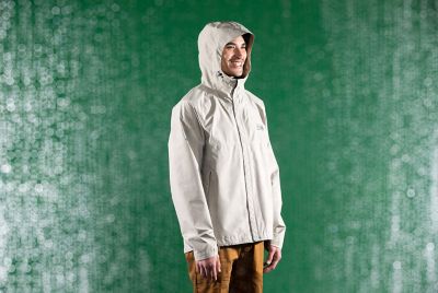 Studio shot Men's Exposure/2 Gore-tex Paclite Jacket in the rain with a green background