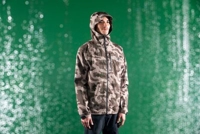 Studio shot of the Men’s Stretch Ozonic™ Jacket in the rain with a green background