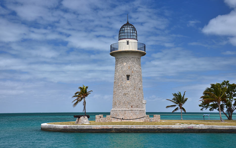 A lighthouse perches on the edge of the sea in a tropical setting at Biscayne National Park.