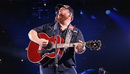 Country singer Luke Combs playing a guitar