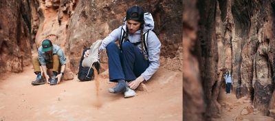 Charlotte hiking in the Utah desert wearing the Dynama/2 pant, gets sand out of her shoe
