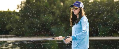 An image of Columbia Sportswear athlete Wesley Locke fishing with a cloud of mosquitoes buzzing around her. 