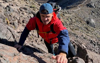 Scott Lehmann (he/him) traversing up a mountain