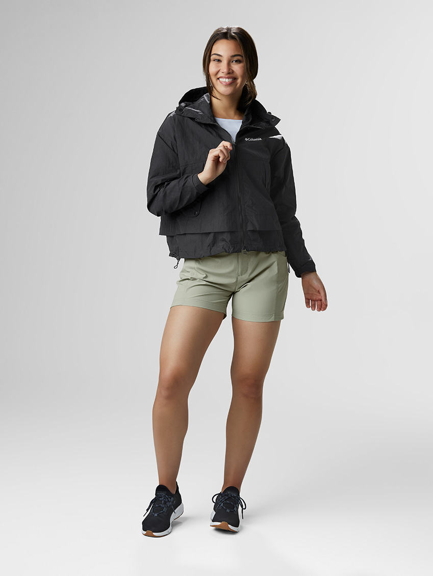 Shorts Story outfit: Cropped black windbreaker jacket with khaki shorts and black sneakers.