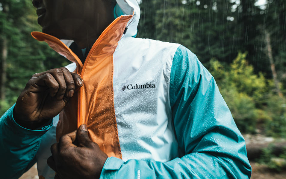 Man zipping up a Columbia color blocked jacket. 