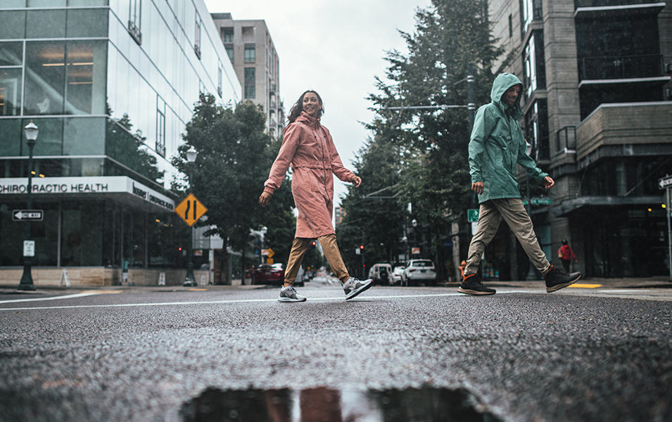 Two people walking in a city street on a rainy day. 