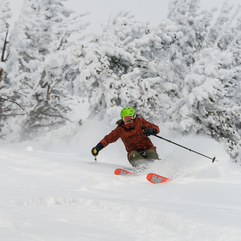 Whiteout, fresh powder conditions as a skier comes down the mountain in the backcountry.