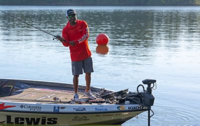 Mark Daniels Jr standing at the front of the boat as he casts out his line while wearing Performance Fishing Gear.