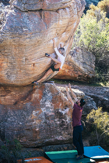 Anna bouldering in Rocklands, South Africa, being spotted by fellow Mountain Hardwear athlete, Jon Glassberg.