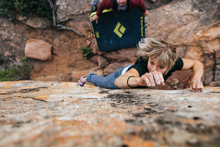Anna bouldering in Rocklands, South Africa, reaching for her next move.
