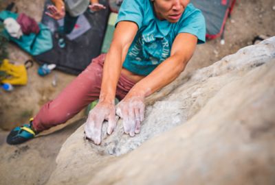 Bouldering near the top, a climber looks for her next hold.
