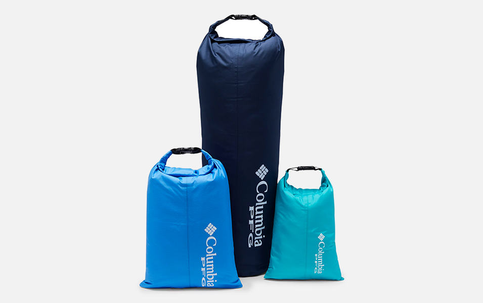 A product image of Columbia Sportswear’s three-piece PFG dry bag set with a white background. The large bag is black, the medium-sized bag is blue, and the small bag is turquoise.