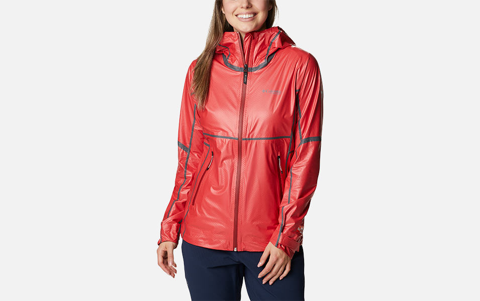 A woman models a red Columbia Sportswear OutDry Extreme mesh shell jacket in a product shot with a white background. 