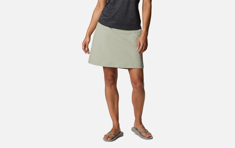 A woman is pictured from the waist down modeling a khaki-colored Columbia Sportswear On The Go skort with a white background. 
