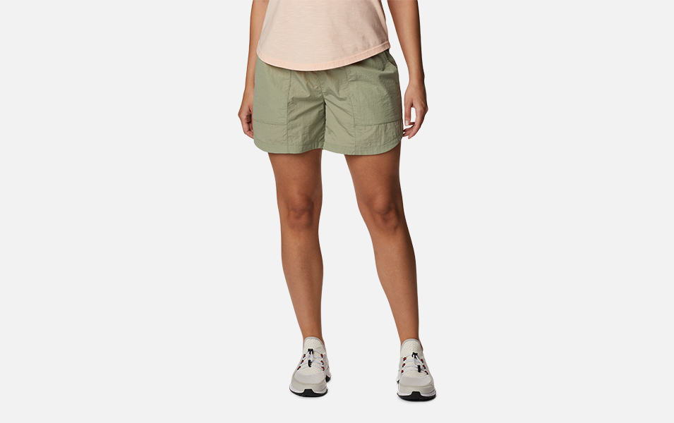 A woman is pictured from the waist down modeling a khaki-colored Columbia Sportswear Women’s Boundless Trek Shortswith a white background. 