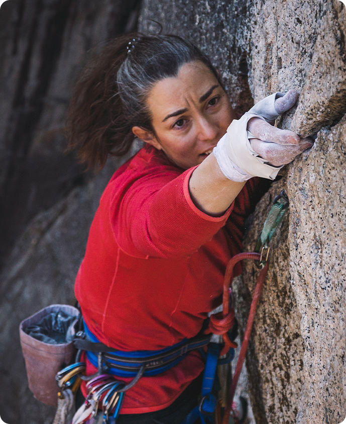 close up of Miranda reaching for a hold while climbing in Yosemite