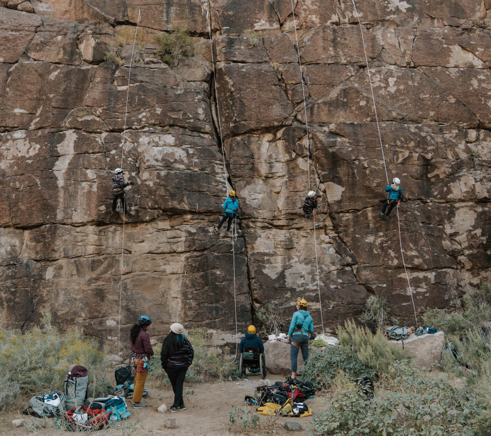 A group shot of past Open Aperture cohorts climbing and taking photos in Red Rocks, NV.