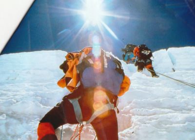 Mountaineer climbing up snow pack wall.