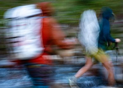 Blurry image of two hikers moving quickly on a backpacking trip.
