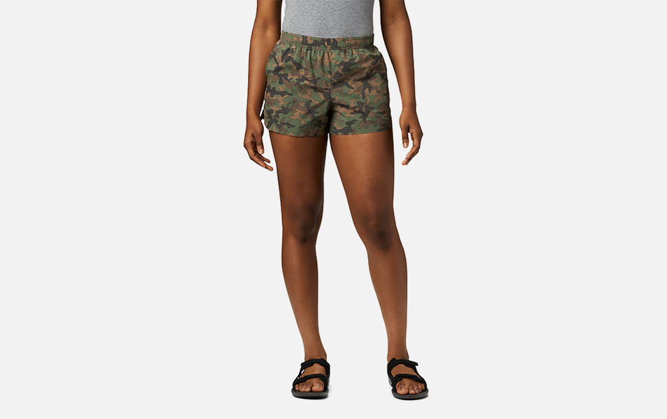 A product shot of a woman wearing cargo Columbia Sportswear Sandy River II printed shorts with a gray background.