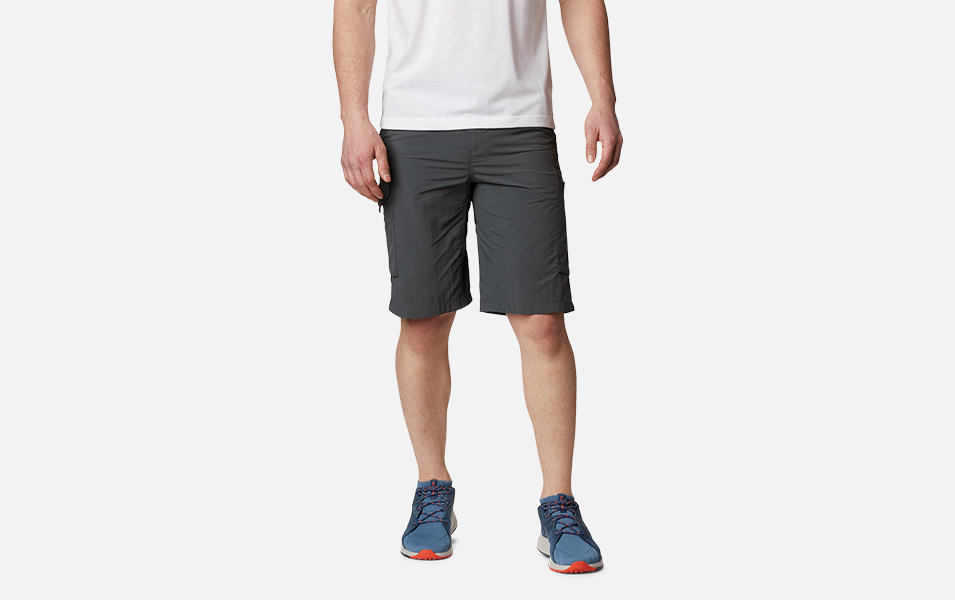A product shot of a man wearing tan-colored Columbia Sportswear Silver Ridge cargo shorts with a gray background.