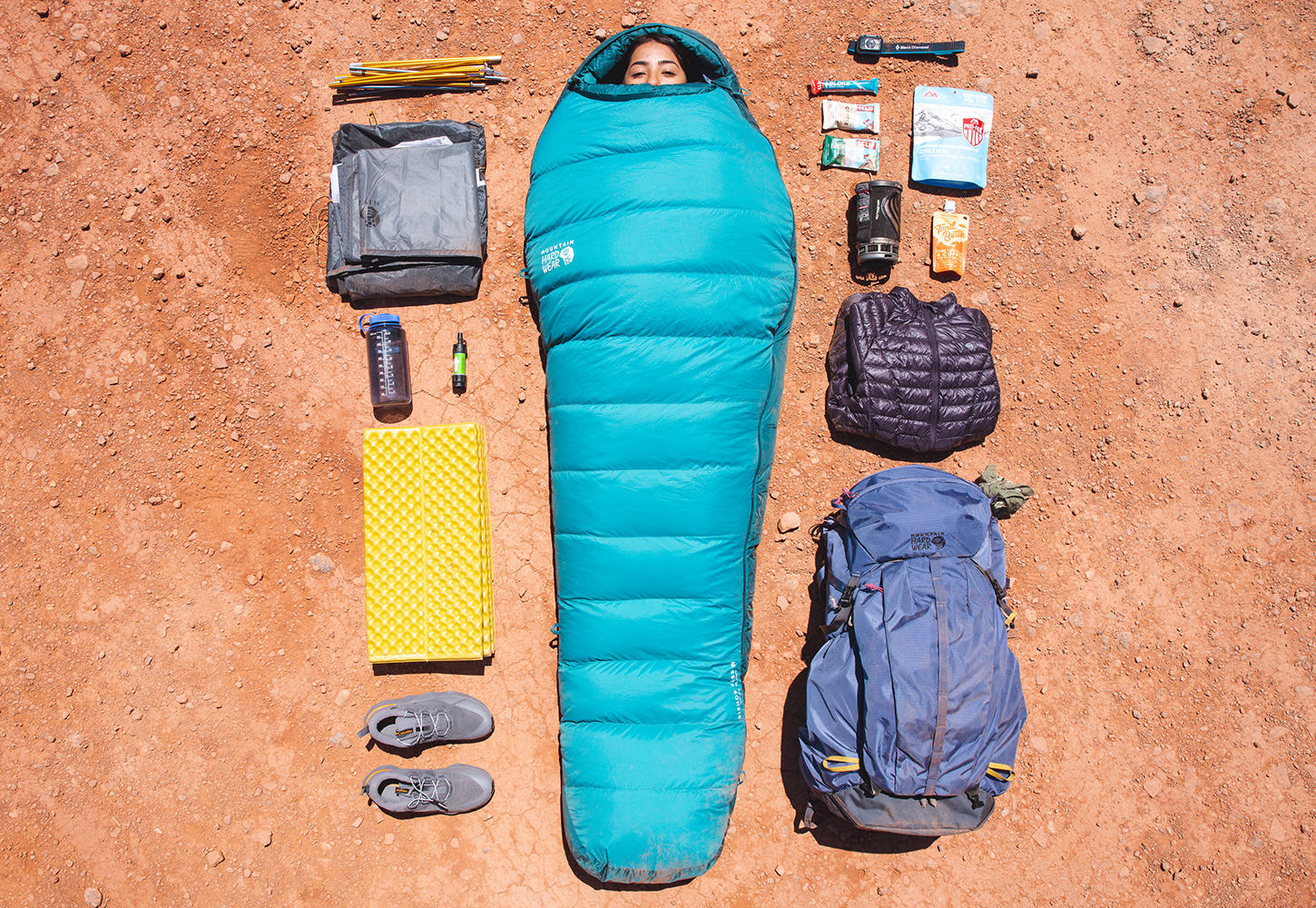 Laydown shot of a backpacker fully cozied up in her sleeping bag