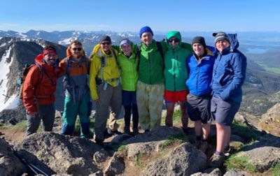 Group of hikers poising at the top of a mountain. 
