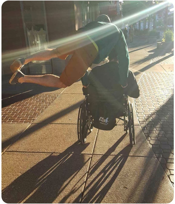Ethan pushing his dad in the wheelchair, jumping for joy