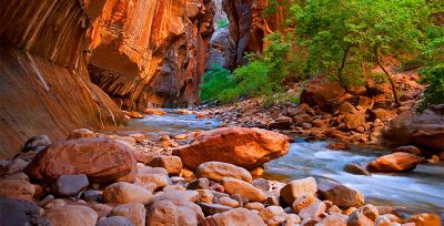 Dramatic sandstone cliffs sweep down to a bubbling brook. 