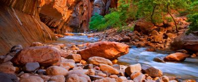 Dramatic sandstone cliffs sweep down to a bubbling brook. 