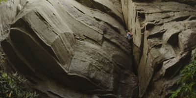 A female climber looks for her next hold on a beautiful rock face.