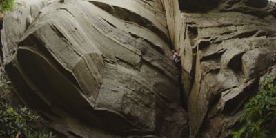 A female climber looks for her next hold on a beautiful rock face.