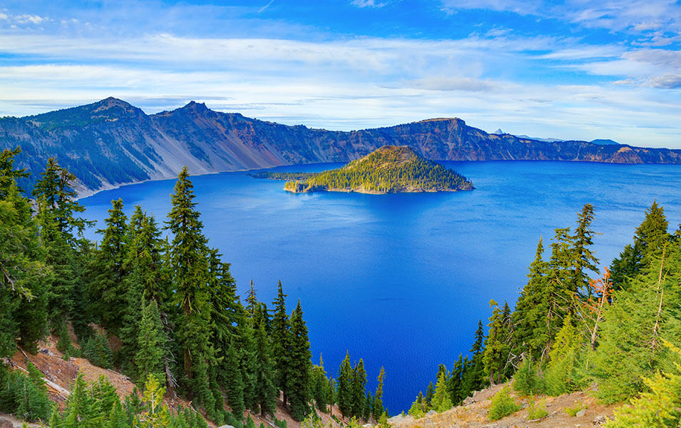 A stunning blue lake is pictured surrounded by mountains in this scenic shot of Oregon’s Crater Lake National Park.