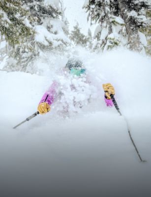 A female skier in deep powder in the backcountry.