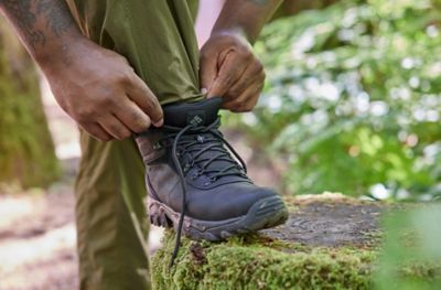 Legs of a hiker adjusting Columbia Sportswear Hiking boots. 