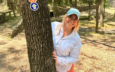 Chelsea McCurdy smiles at the camera wearing Columbia Sportswear’s Leslie Falls™ plus-size hiking shirt.