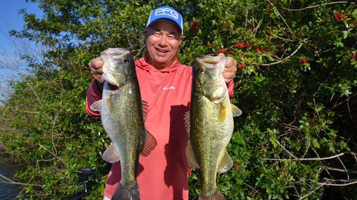 Bob Izumi holds up two fish he caught. 