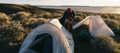 Two Nimbus tents set up on a backpacking trip by a lake in the distance.