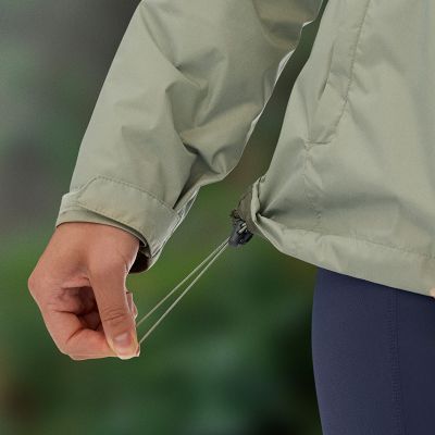 Close-up of a person adjusting the wait of the jacket using a cinchable drawcord.