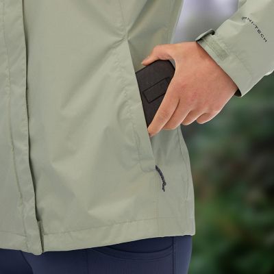 Close-up of a person putting their phone into the zipping hand pocket.