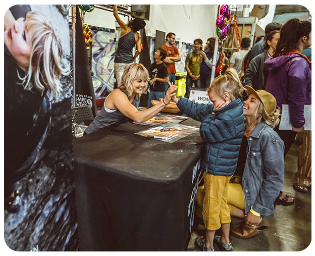 MHW athlete Anna Liina Laitinen high fives a young girl at the event while signing posters