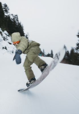 A snowboarder getting some air while coming down a run.