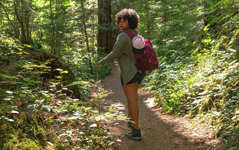 Female hiking on trail in woods 